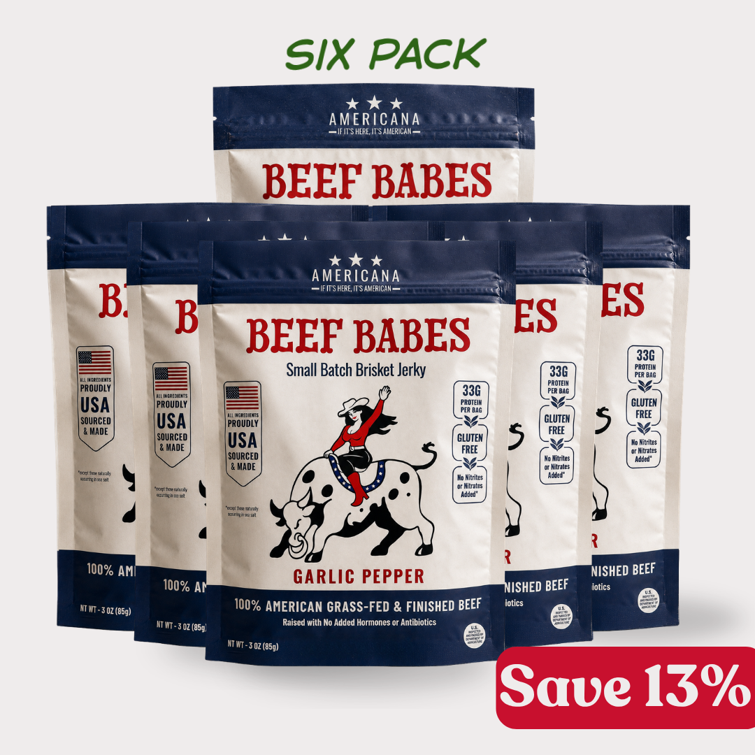 Six bags of Americana Beef Babes Small Batch Brisket Jerky in Garlic Pepper flavor, arranged in a pack display on a light gray background with 'SIX PACK' text at the top and a red 'Save 13%' banner at the bottom right.