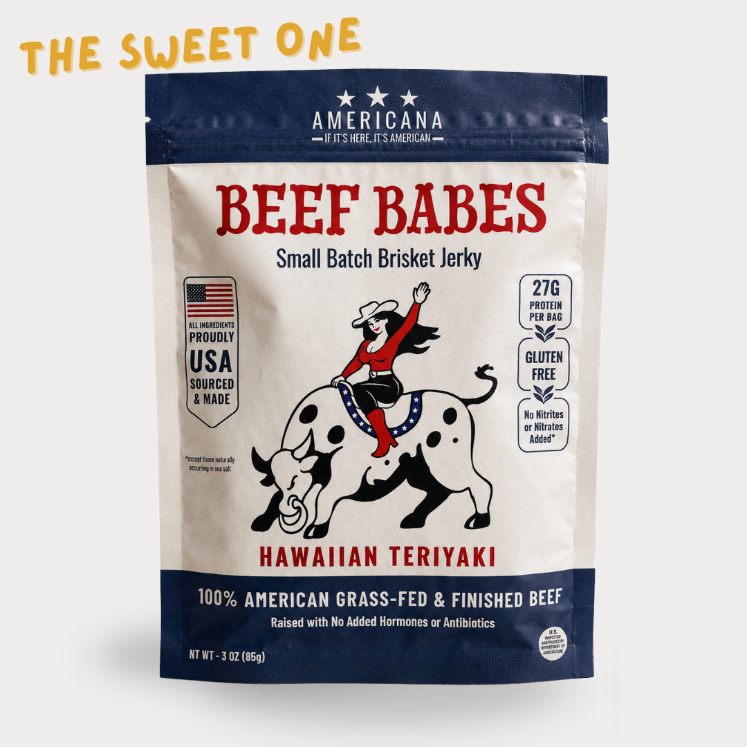 A stand-up pouch of American Beef Babes Hawaiian Teriyaki Small Batch Brisket Jerky, featuring a cream and navy design with red lettering and an illustration of a cowboy on a dalmatian bull. The package is shown on a light gray background with 'THE SWEET ONE' text in yellow at the top left.