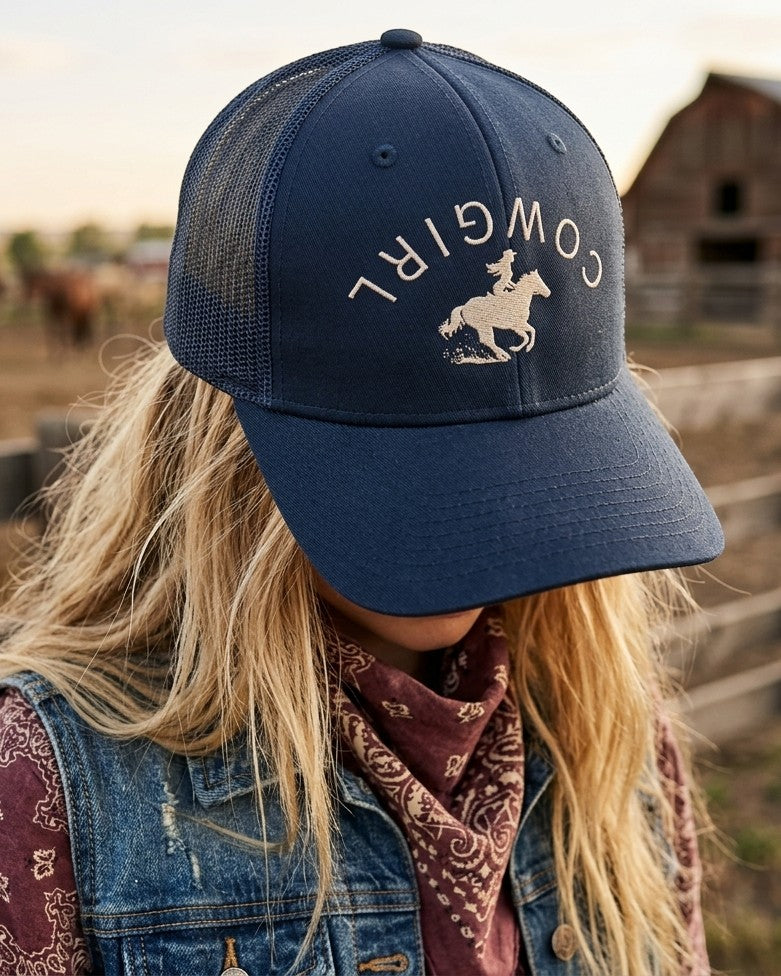Americana navy blue trucker hat with a cowgirl graphic, featuring a breathable mesh back and adjustable snapback.